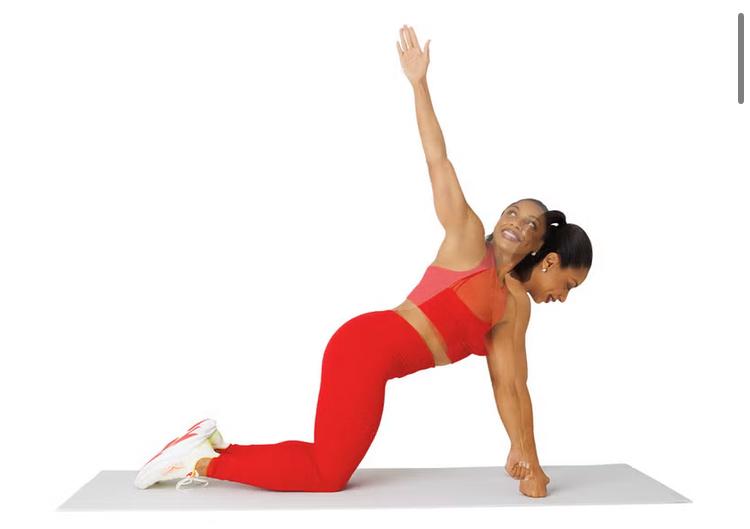 Een vrouw zit op handen en knieën op een yogamatje en voert de T-Spine Rotation uit